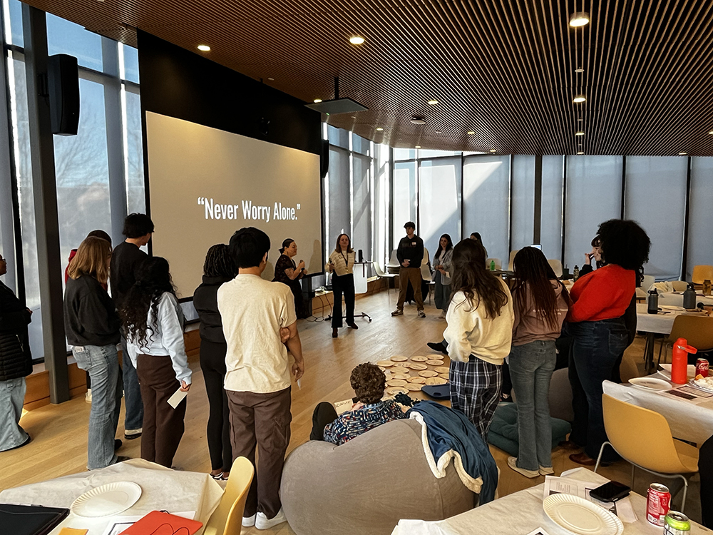 Participants standing around a screen at a BWell Workshop